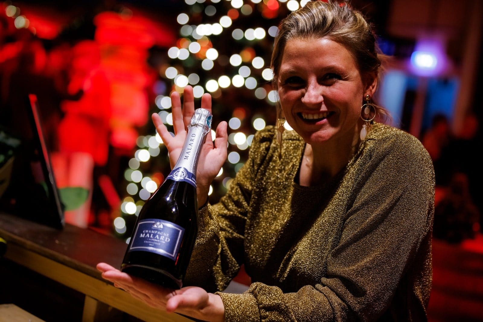Linda met champagnefles tijdens een sfeervol kerstfeest en bedrijfsevent van Let's Go Events